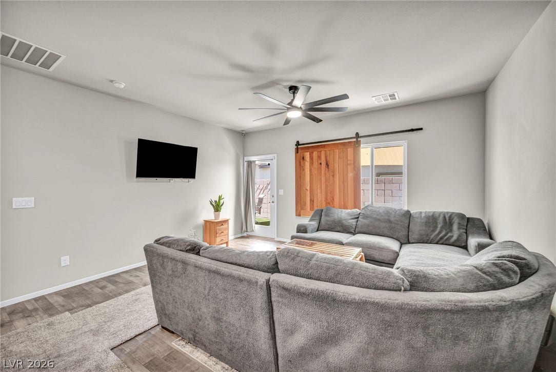 Smooth plaster walls and rich wood-look flooring establish a relaxed tone in this comfortable living area.