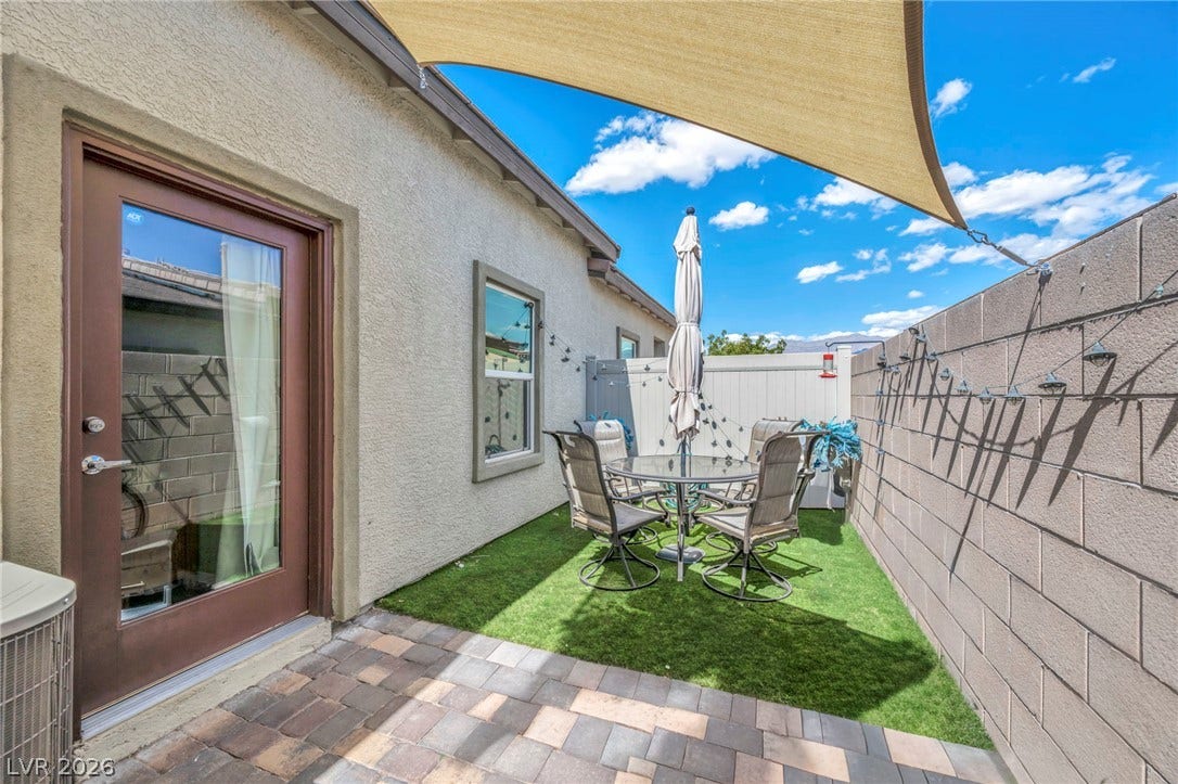 An intimate courtyard features a paver stone patio bordered by durable stucco walls.
