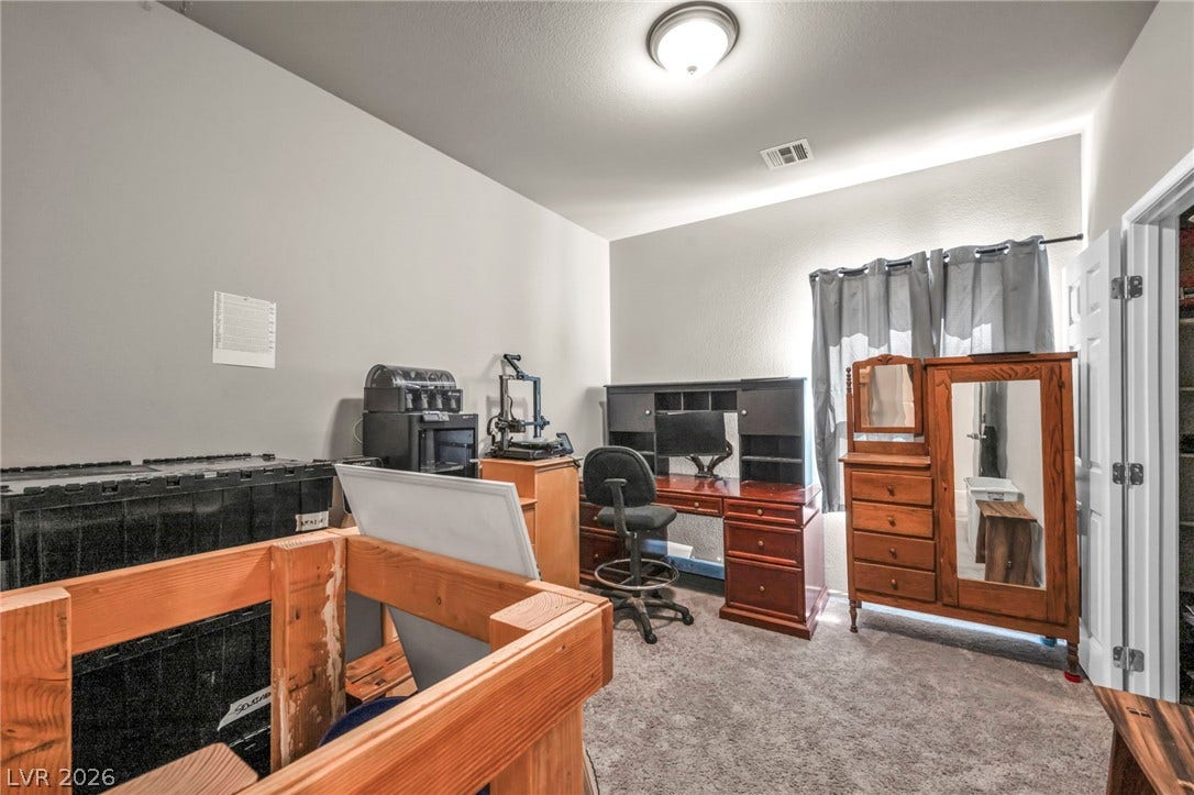 A versatile secondary bedroom features plush carpeting and a large window providing natural light.