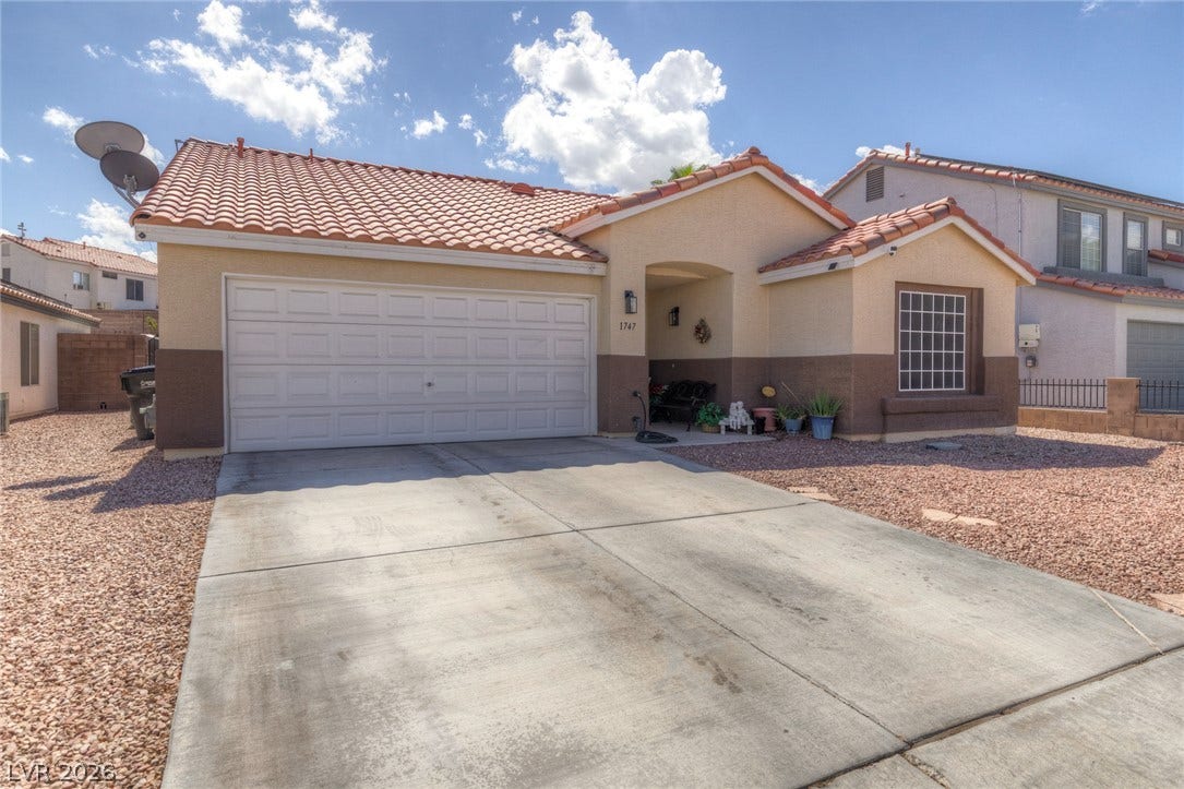 1747 Ashburn Drive, North Las Vegas, NV 89032 An inviting exterior features a concrete driveway, stucco walls, and a classic tile roof.