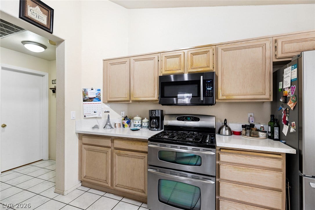 1747 Ashburn Drive, North Las Vegas, NV 89032 Oak cabinetry paired with durable tile flooring creates a classic and functional culinary space.