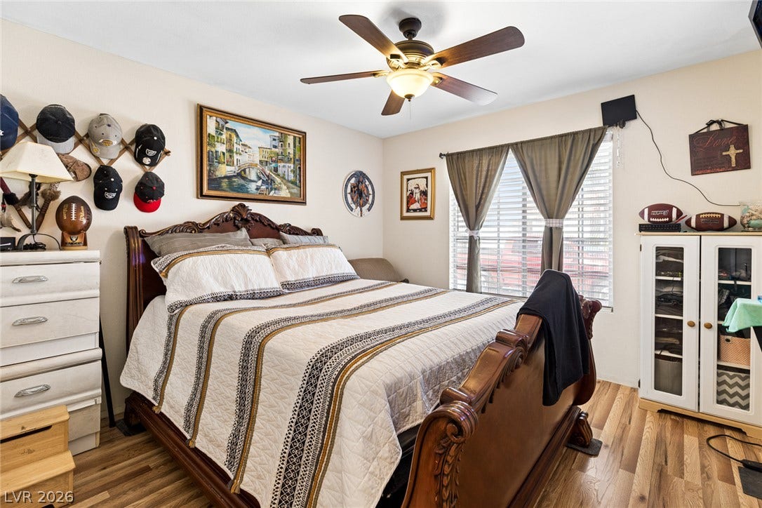 1747 Ashburn Drive, North Las Vegas, NV 89032 Warm wood flooring and natural light through large windows anchor this comfortable bedroom space.