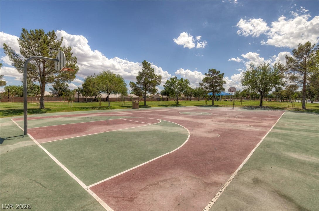1747 Ashburn Drive, North Las Vegas, NV 89032 An outdoor community basketball court stands ready for play, surrounded by grassy fields and mature trees.