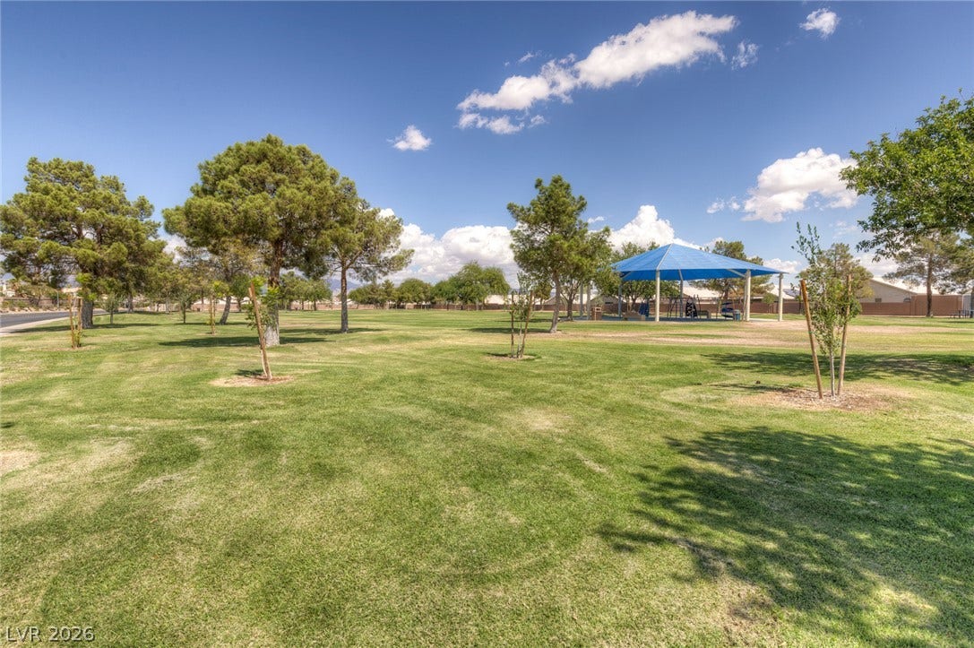 1747 Ashburn Drive, North Las Vegas, NV 89032 Mature shade trees and manicured lawns frame a community playground beneath blue skies.