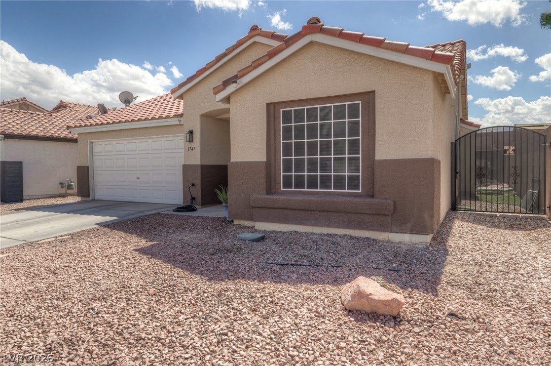 1747 Ashburn Drive, North Las Vegas, NV 89032 Classic stucco exterior and barrel tile roofing define this single-story desert home.