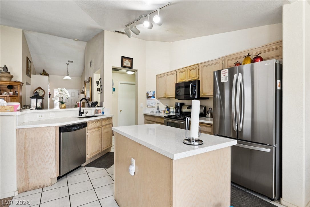 1747 Ashburn Drive, North Las Vegas, NV 89032 Functional layout highlights this cooking area featuring tile flooring and a central island.