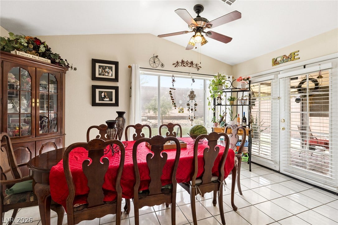 1747 Ashburn Drive, North Las Vegas, NV 89032 Tiled flooring and a vaulted ceiling elevate this sunlit dining space featuring glass patio doors.