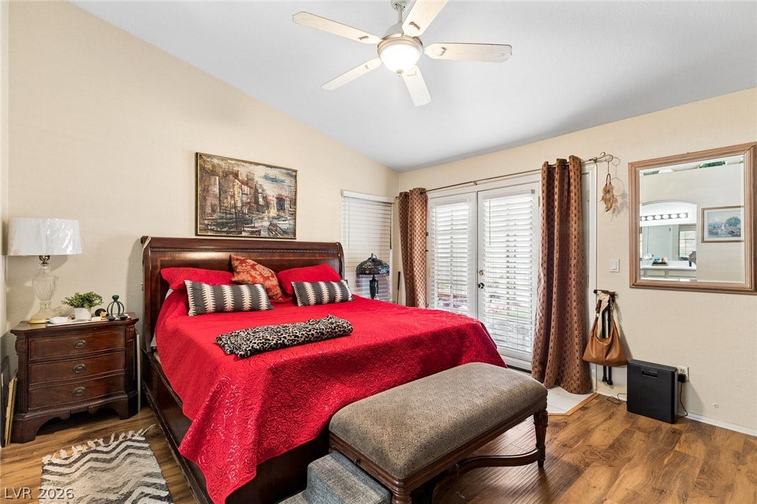 1747 Ashburn Drive, North Las Vegas, NV 89032 Rich wood flooring runs throughout this bedroom featuring French doors that open to the outside.