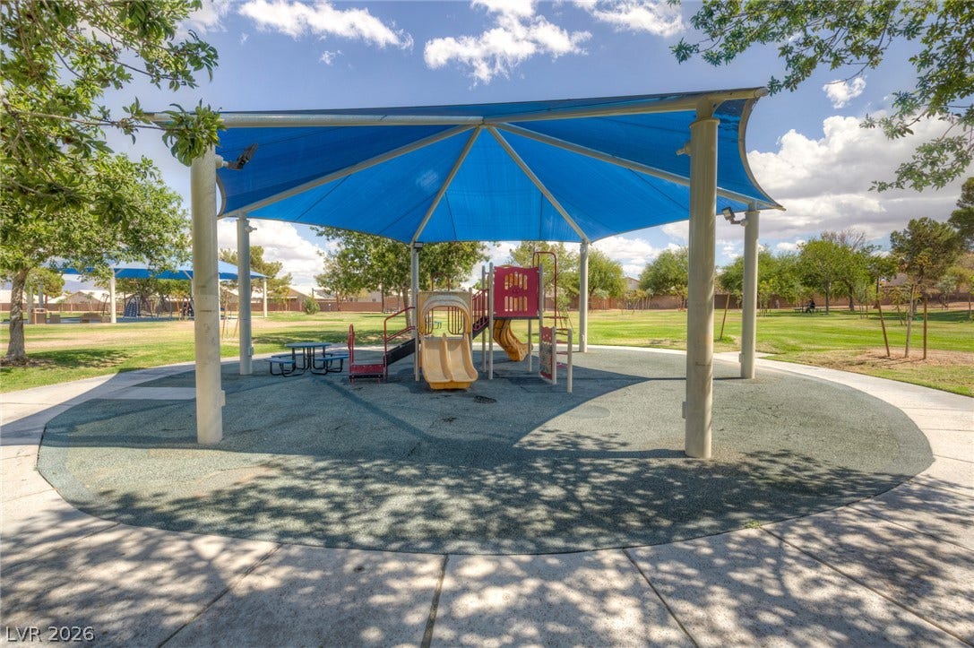 1747 Ashburn Drive, North Las Vegas, NV 89032 A shaded community playground structure sits amid manicured lawns and mature trees in a neighborhood park.