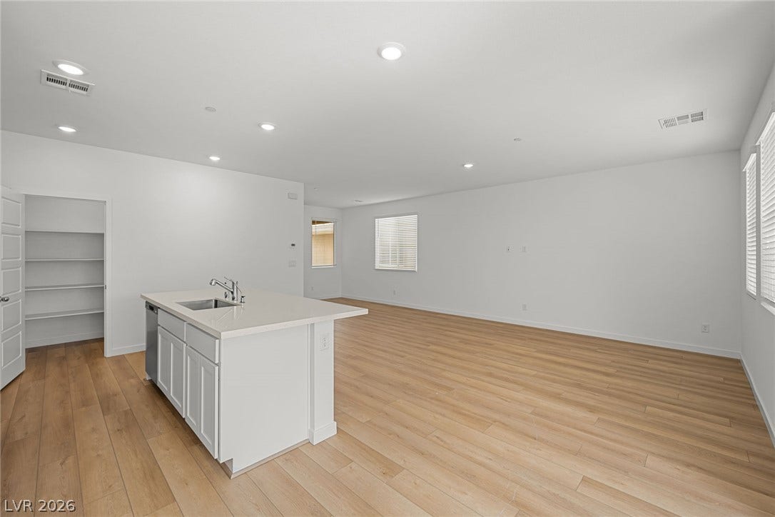 8142 Gusty Brook Street, Las Vegas, NV 89113 Smooth wood floors flow through this light-filled kitchen and expansive living area.