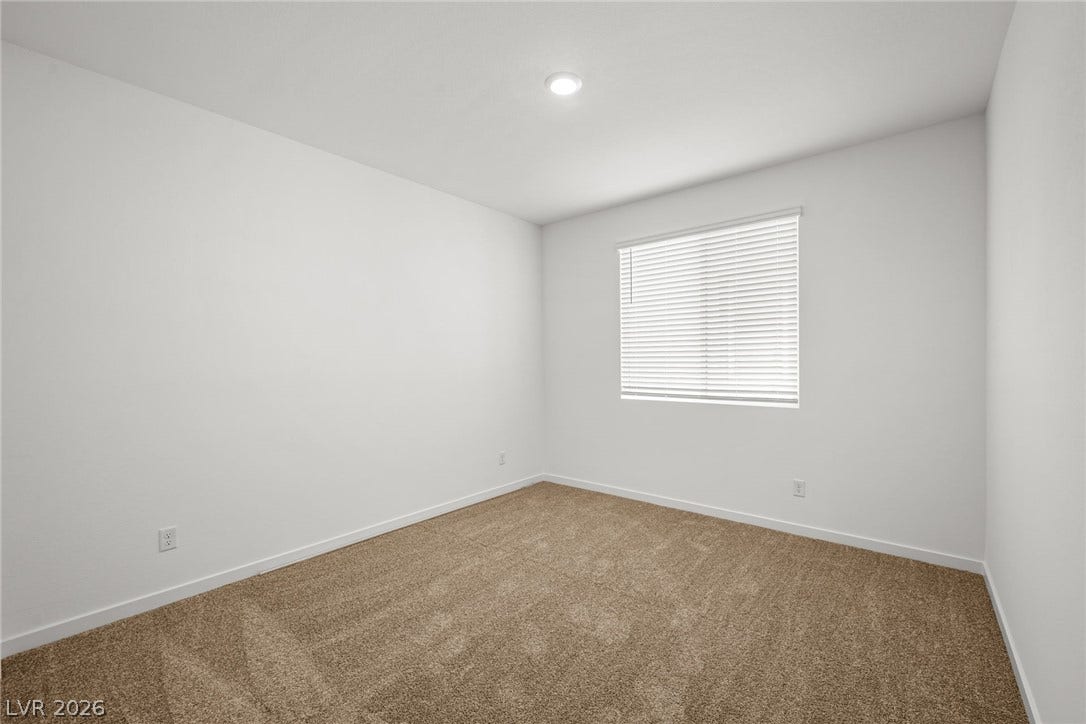 8142 Gusty Brook Street, Las Vegas, NV 89113 Plush carpeting and a wide window with integrated blinds create a serene bedroom environment.