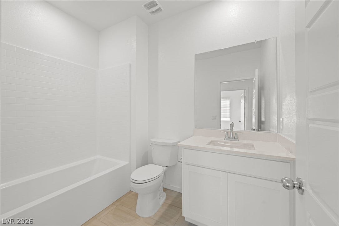 8142 Gusty Brook Street, Las Vegas, NV 89113 Clean lines and classic tiling define this well-appointed bathroom space.