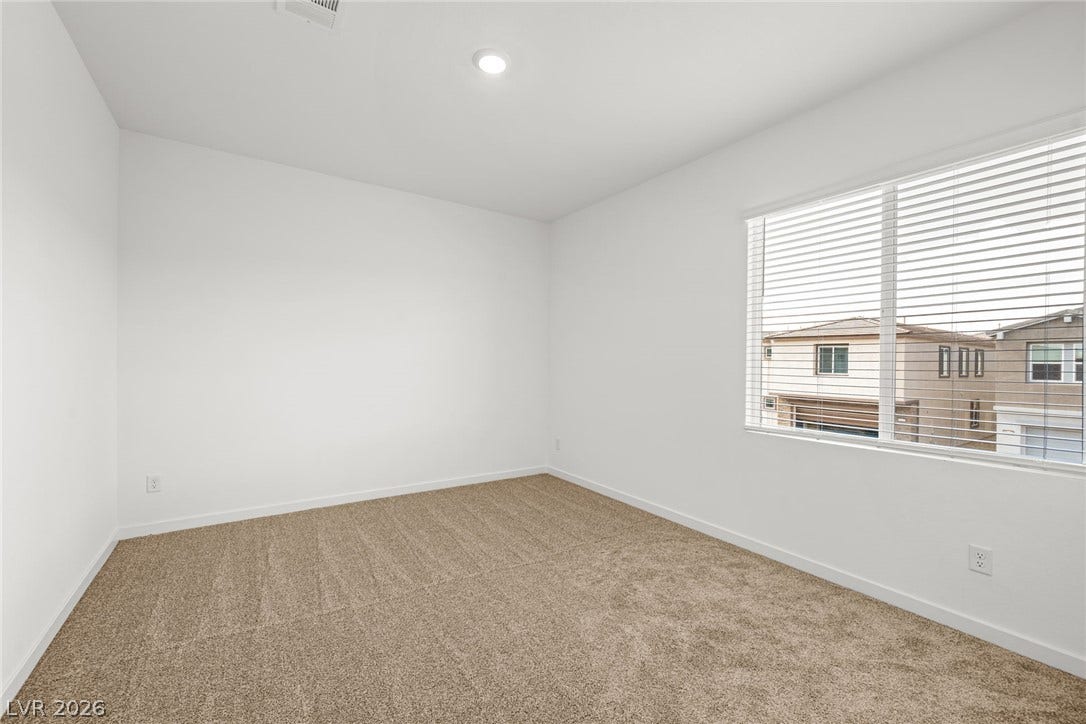 8142 Gusty Brook Street, Las Vegas, NV 89113 Plush carpeting and recessed lighting create a comfortable, minimalist bedroom space.