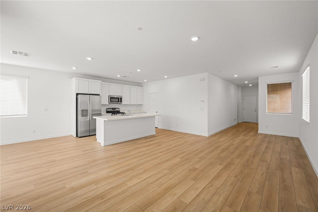 8142 Gusty Brook Street, Las Vegas, NV 89113 Gleaming wood floors anchor a spacious open-concept kitchen and living area bathed in light.