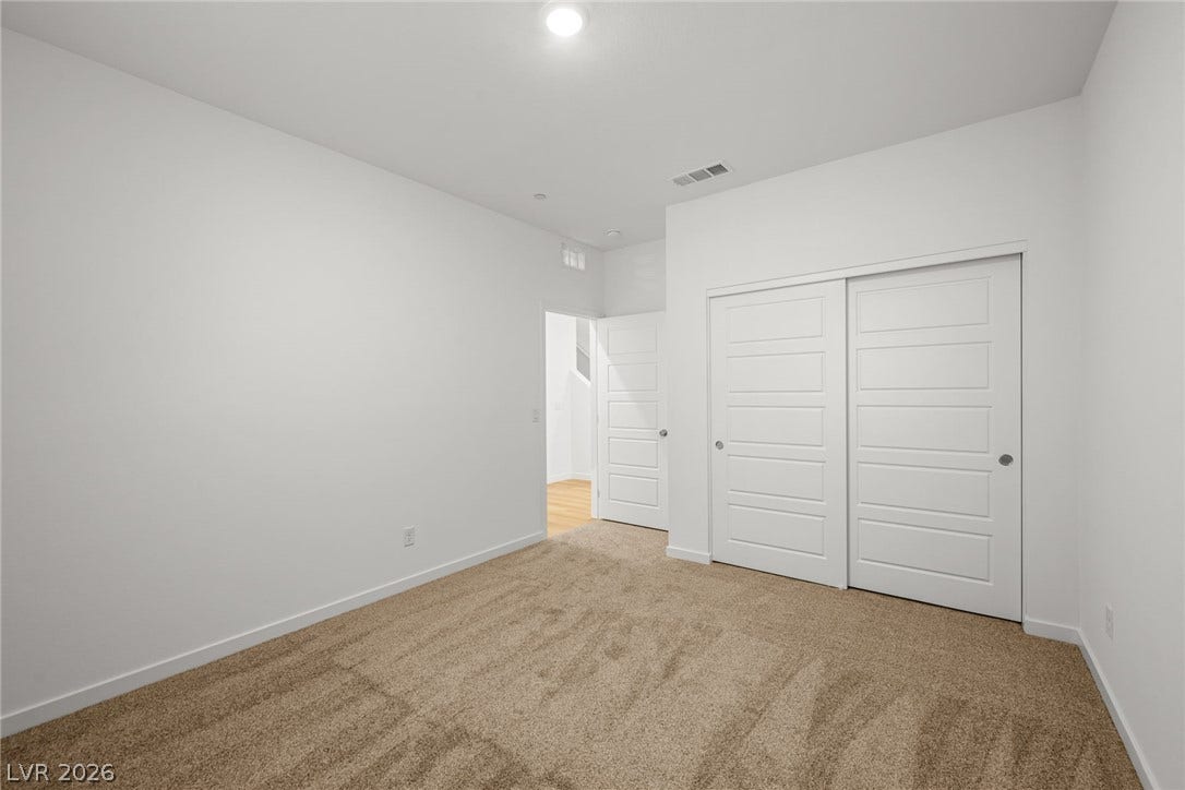8142 Gusty Brook Street, Las Vegas, NV 89113 Soft carpeting pairs with crisp white walls under a high ceiling in this serene space.