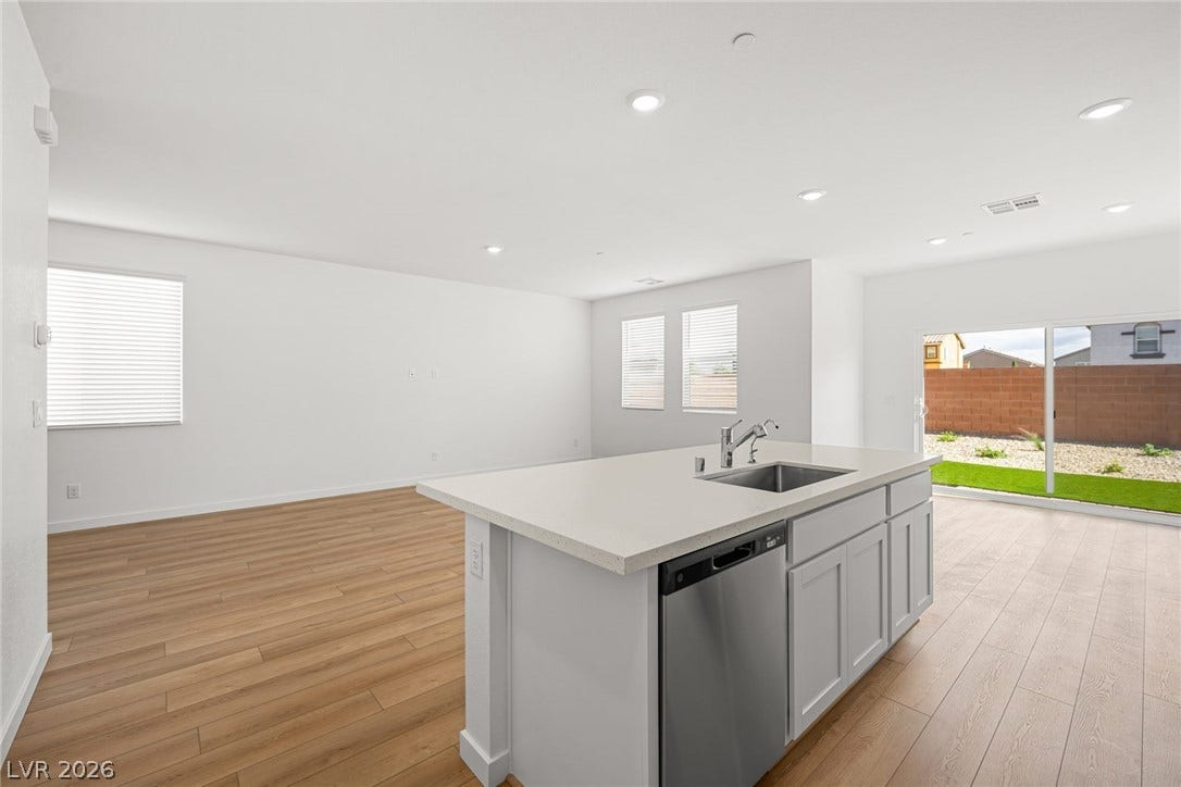 8142 Gusty Brook Street, Las Vegas, NV 89113 Clean lines and warm wood floors define this open-concept kitchen and living area.