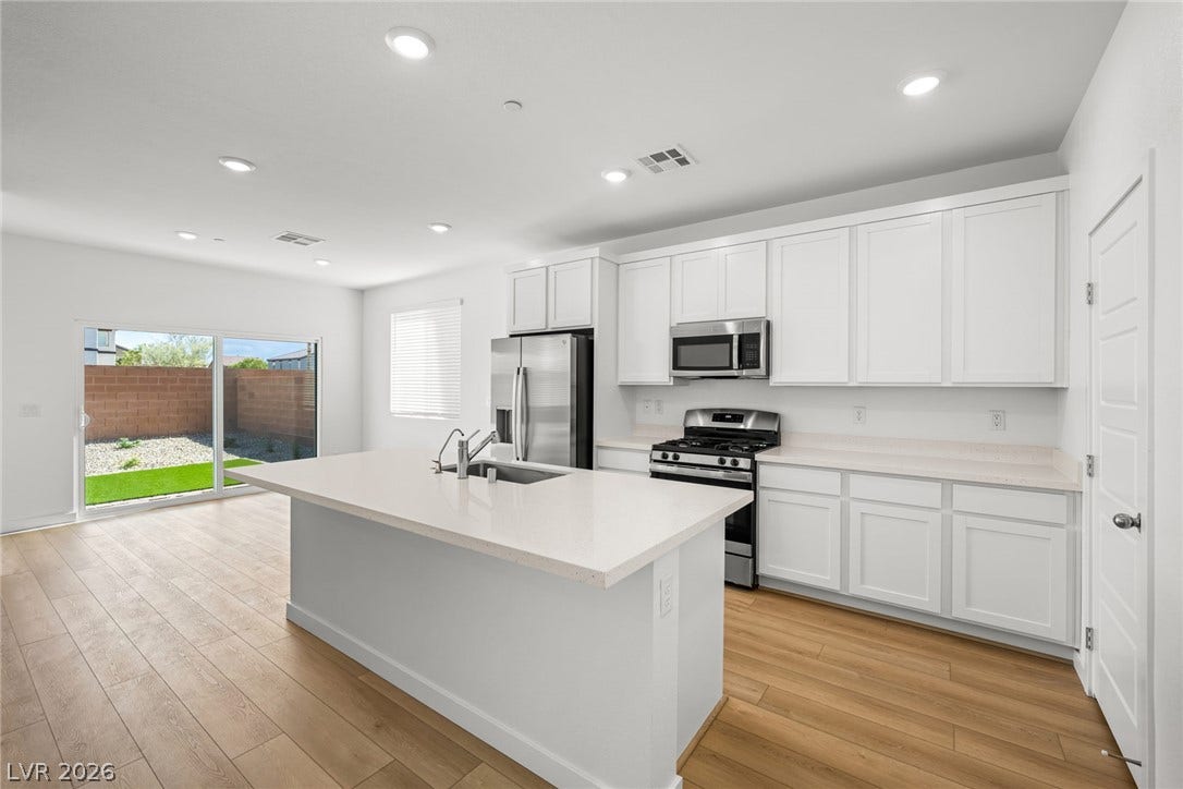8142 Gusty Brook Street, Las Vegas, NV 89113 Gleaming wood flooring complements the quartz counters and crisp white cabinetry of this kitchen.