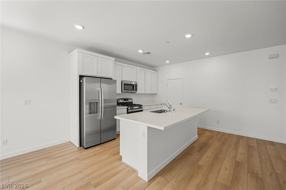 8142 Gusty Brook Street, Las Vegas, NV 89113 Smooth wood floors anchor this contemporary kitchen, which is centered around a functional white island.