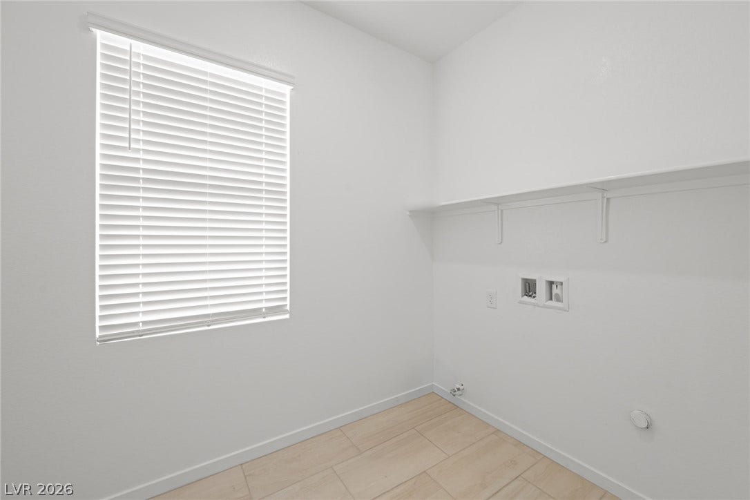 8142 Gusty Brook Street, Las Vegas, NV 89113 Natural light pours through a large window, illuminating the spacious utility area with integrated shelving.