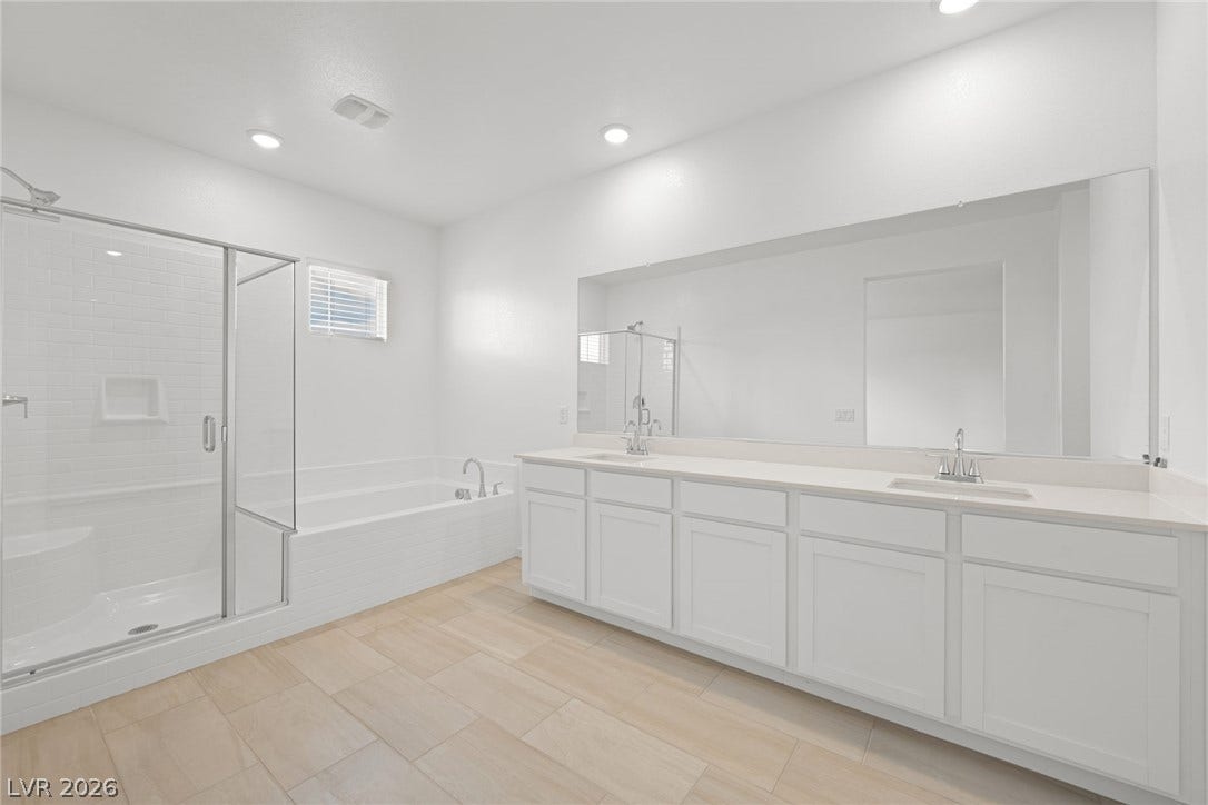 8142 Gusty Brook Street, Las Vegas, NV 89113 Clean lines and ceramic tile flooring define this spacious bathroom with a glass-enclosed shower.