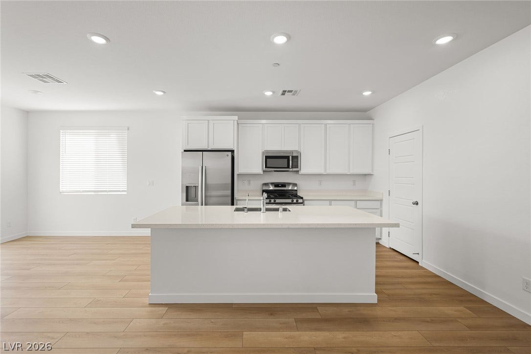 8142 Gusty Brook Street, Las Vegas, NV 89113 Clean lines and warm wood floors define this bright, contemporary kitchen with a central island.