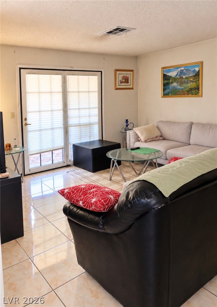 101 Luna Way, #242, Las Vegas, NV 89145 Polished tile flooring and double glass doors define this comfortable living area.