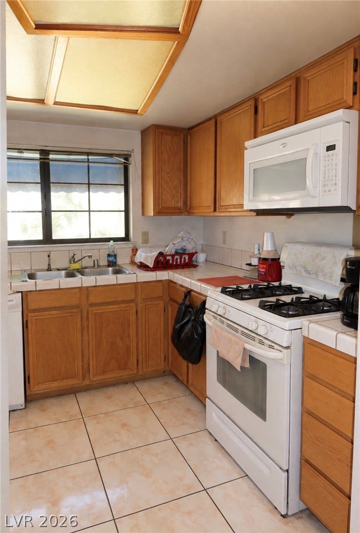 101 Luna Way, #242, Las Vegas, NV 89145 Ample wooden cabinetry and ceramic tile flooring define this highly functional cooking space.