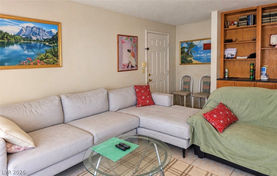 101 Luna Way, #242, Las Vegas, NV 89145 Built-in shelving adds storage to this comfortable living area featuring neutral tile flooring.
