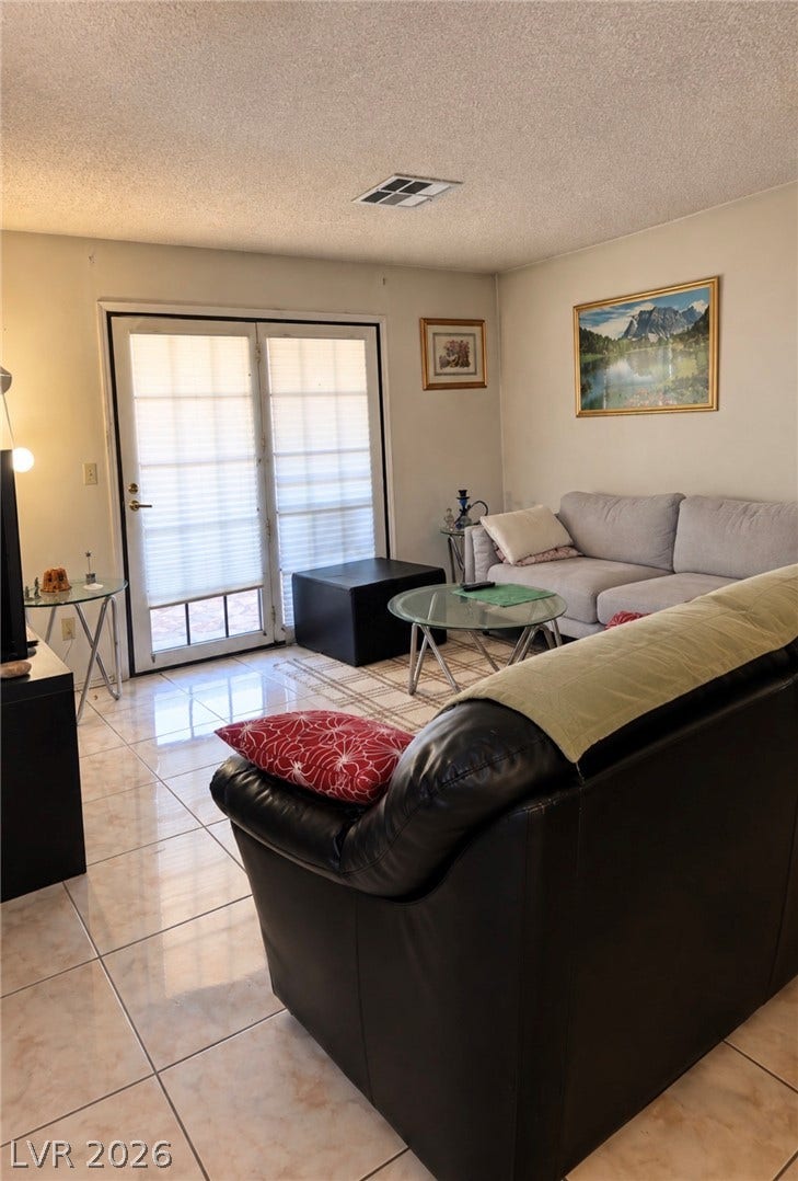 101 Luna Way, #242, Las Vegas, NV 89145 Polished tile flooring and double glass doors define this comfortable living area.
