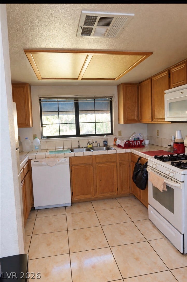 101 Luna Way, #242, Las Vegas, NV 89145 Ample wooden cabinetry and ceramic tile flooring define this functional cooking space.