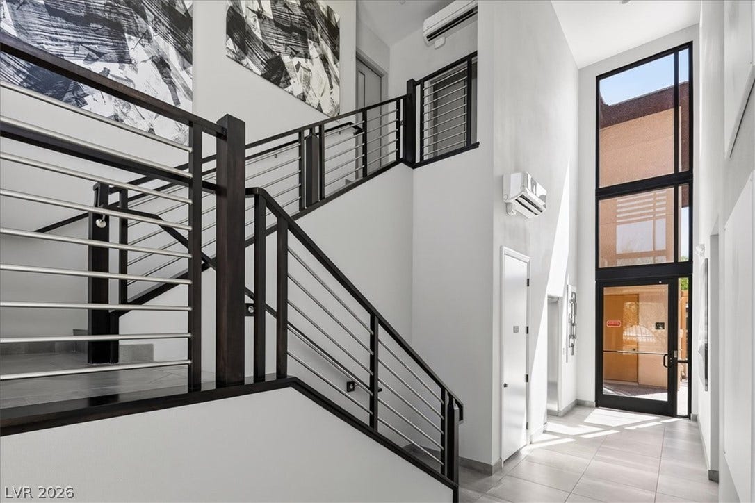 11280 Granite Ridge Drive, #1048, Las Vegas, NV 89135 Dramatic multi-story windows fill this modern entry and staircase with abundant natural light.