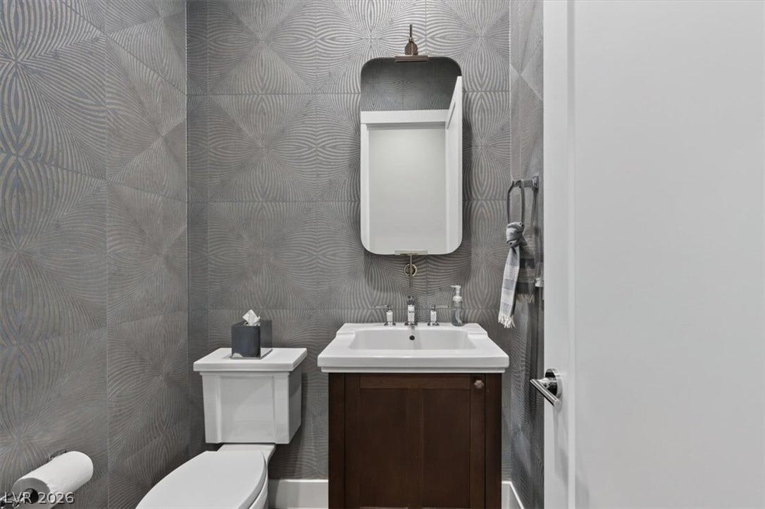 11280 Granite Ridge Drive, #1048, Las Vegas, NV 89135 Textured wall coverings and a rich wood vanity bring refined character to this powder room.