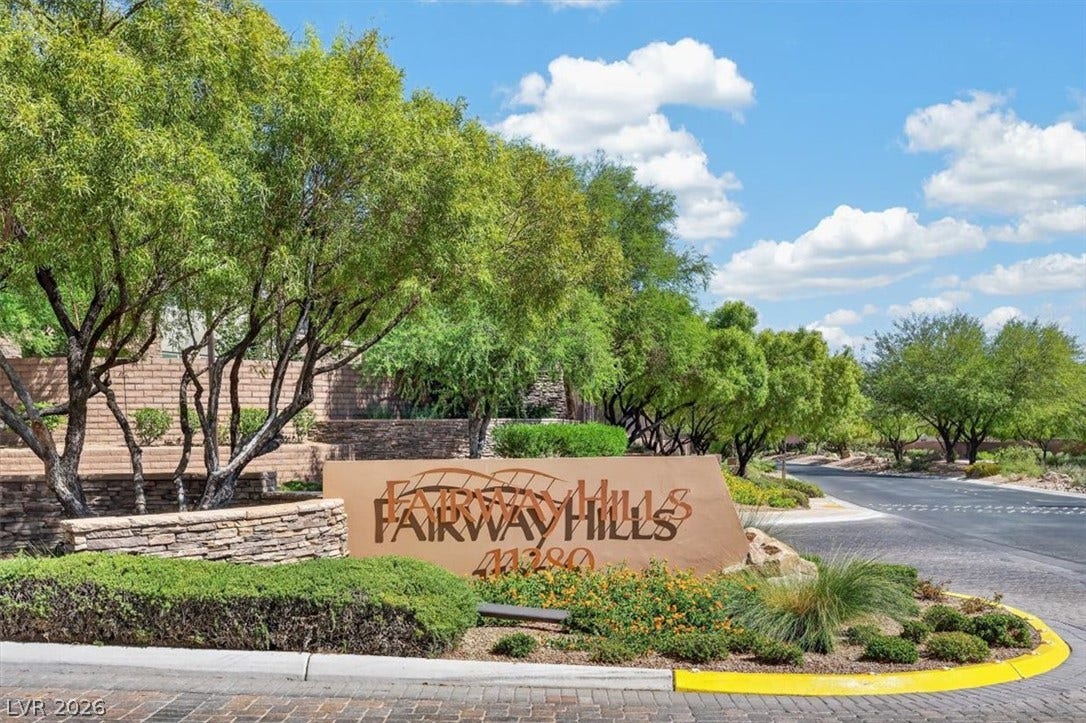 11280 Granite Ridge Drive, #1048, Las Vegas, NV 89135 Lush landscaping frames the monumental stone-accented community sign along the entrance drive.