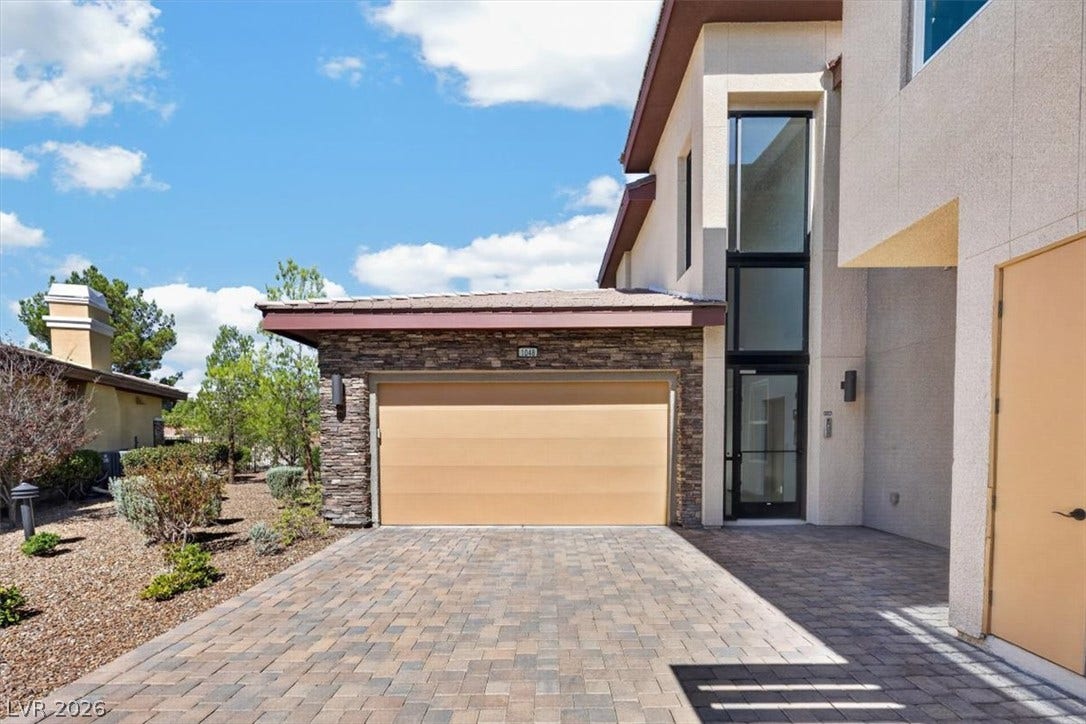 11280 Granite Ridge Drive, #1048, Las Vegas, NV 89135 A paved driveway leads to a modern stucco facade accented by natural stone elements.