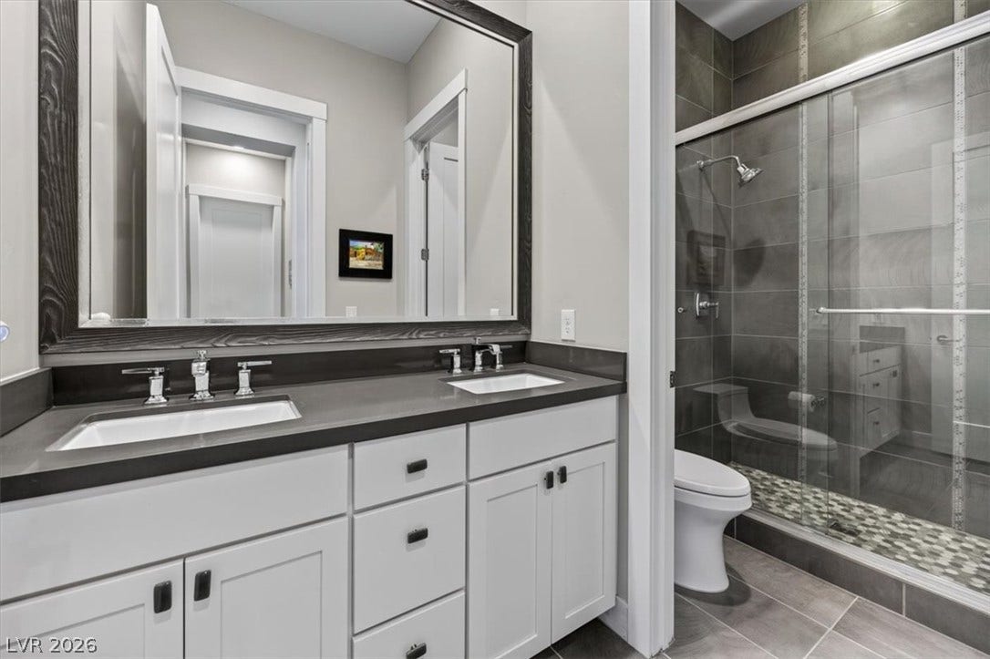 11280 Granite Ridge Drive, #1048, Las Vegas, NV 89135 A contemporary double vanity pairs with a glass-enclosed walk-in shower featuring custom tile work.