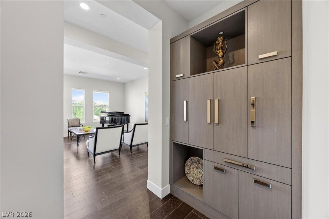 11280 Granite Ridge Drive, #1048, Las Vegas, NV 89135 Rich wood flooring flows past a custom built-in cabinet into an inviting living space.