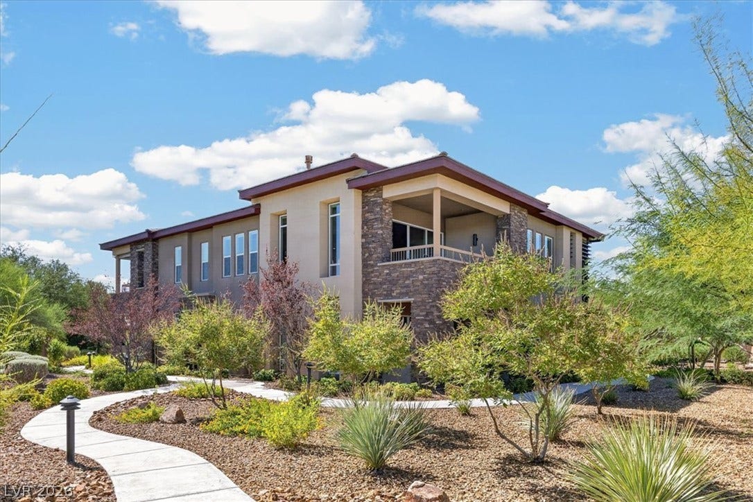 11280 Granite Ridge Drive, #1048, Las Vegas, NV 89135 Desert plantings frame a curved walkway leading toward this contemporary stone and stucco exterior.