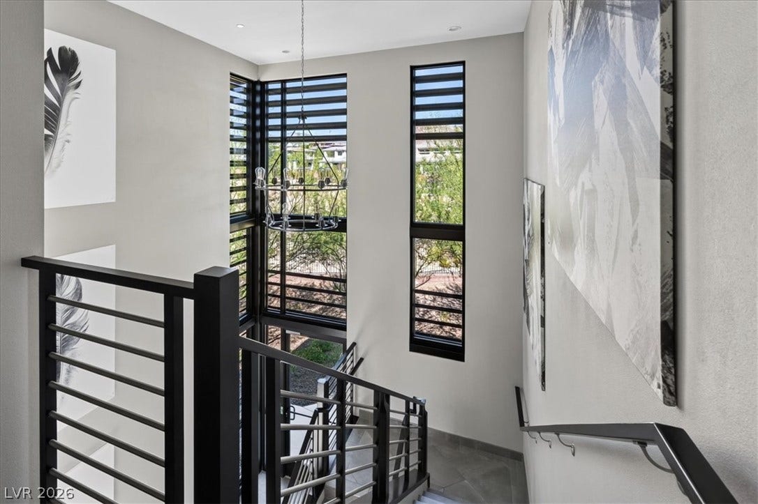 11280 Granite Ridge Drive, #1048, Las Vegas, NV 89135 Dramatic multi-story windows frame neighborhood views from this modern staircase with a custom metal railing.