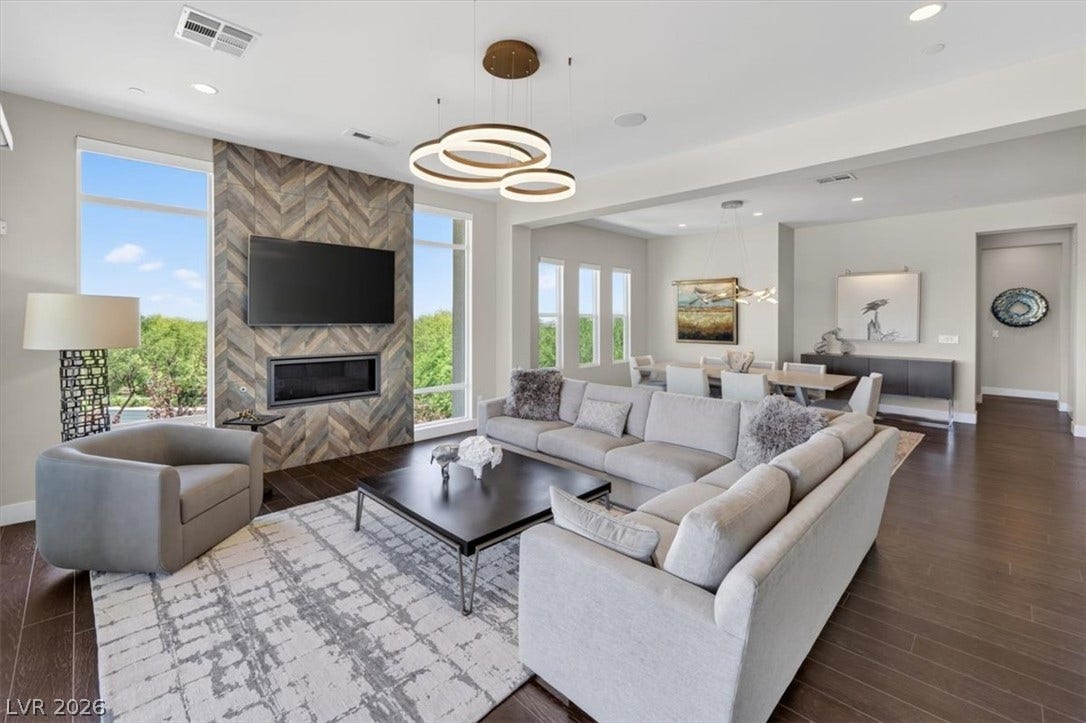 11280 Granite Ridge Drive, #1048, Las Vegas, NV 89135 Gleaming hardwood floors and a modern tiled fireplace anchor this expansive open-concept living space.