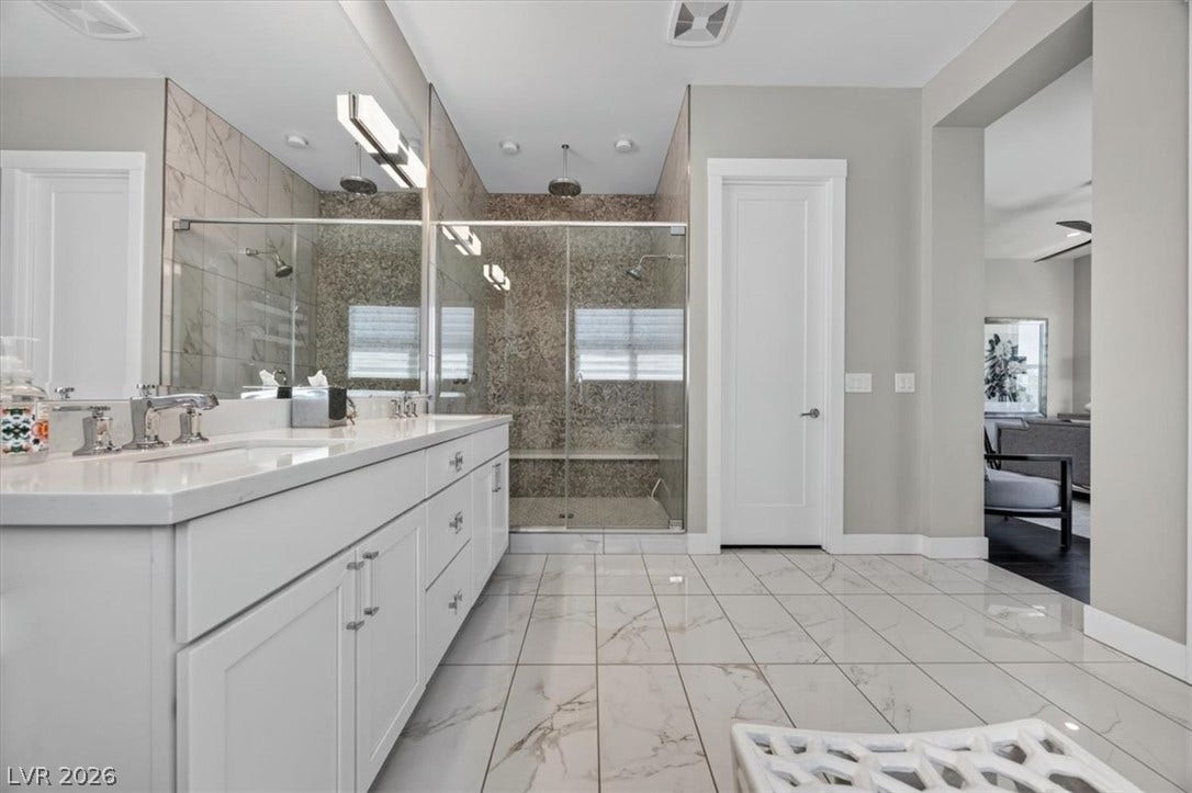 11280 Granite Ridge Drive, #1048, Las Vegas, NV 89135 Polished tile flooring and a glass-enclosed shower elevate this spacious modern bathroom.
