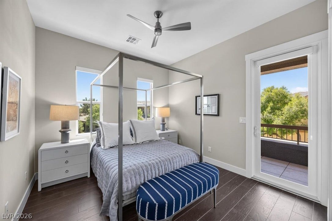 11280 Granite Ridge Drive, #1048, Las Vegas, NV 89135 Rich wood floors and tall ceilings define this peaceful bedroom opening directly onto a private balcony.