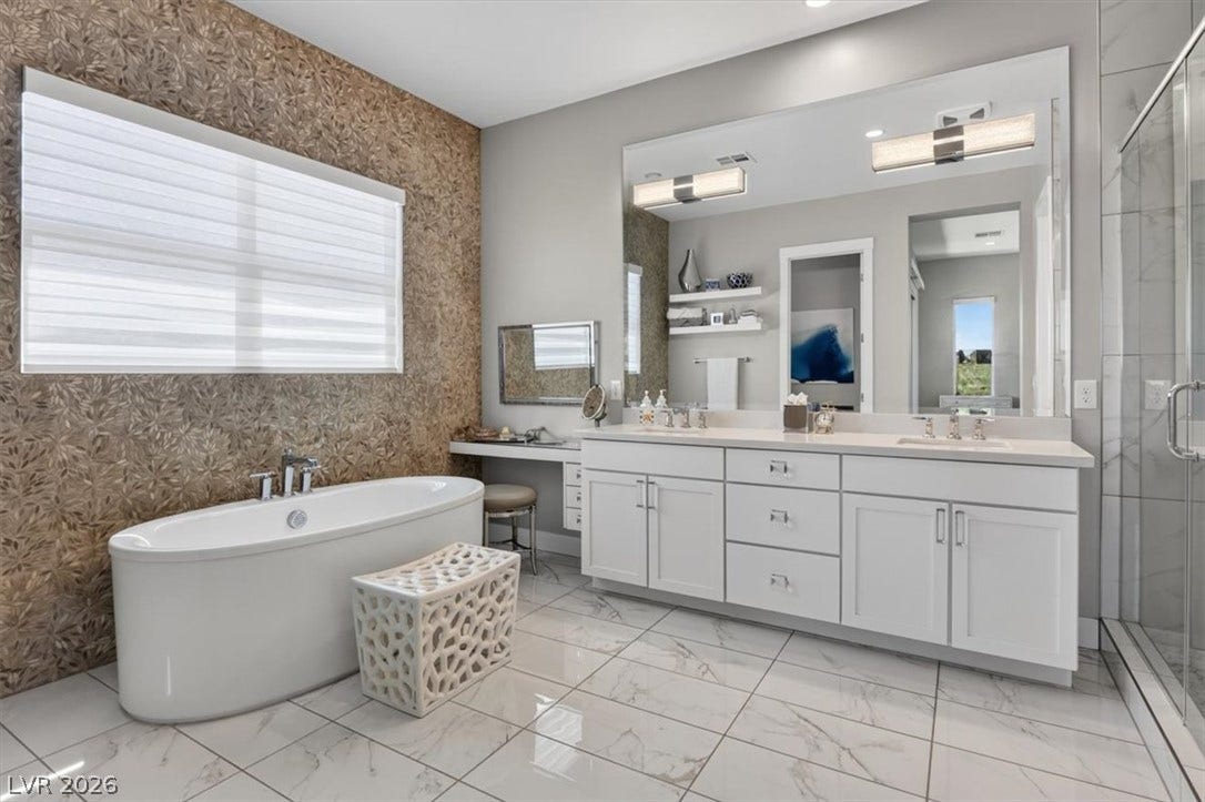 11280 Granite Ridge Drive, #1048, Las Vegas, NV 89135 A freestanding tub and large vanity create a refined atmosphere on polished tile flooring.
