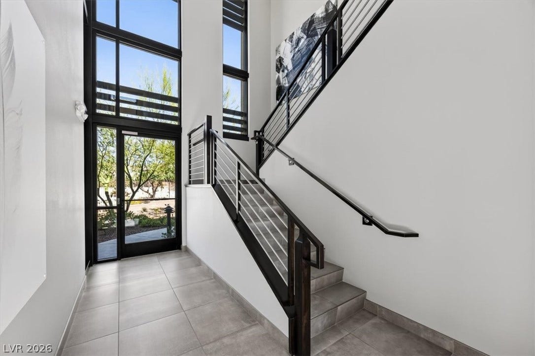 11280 Granite Ridge Drive, #1048, Las Vegas, NV 89135 Sleek tile flooring and towering multi-tier windows elevate this modern architectural entryway.