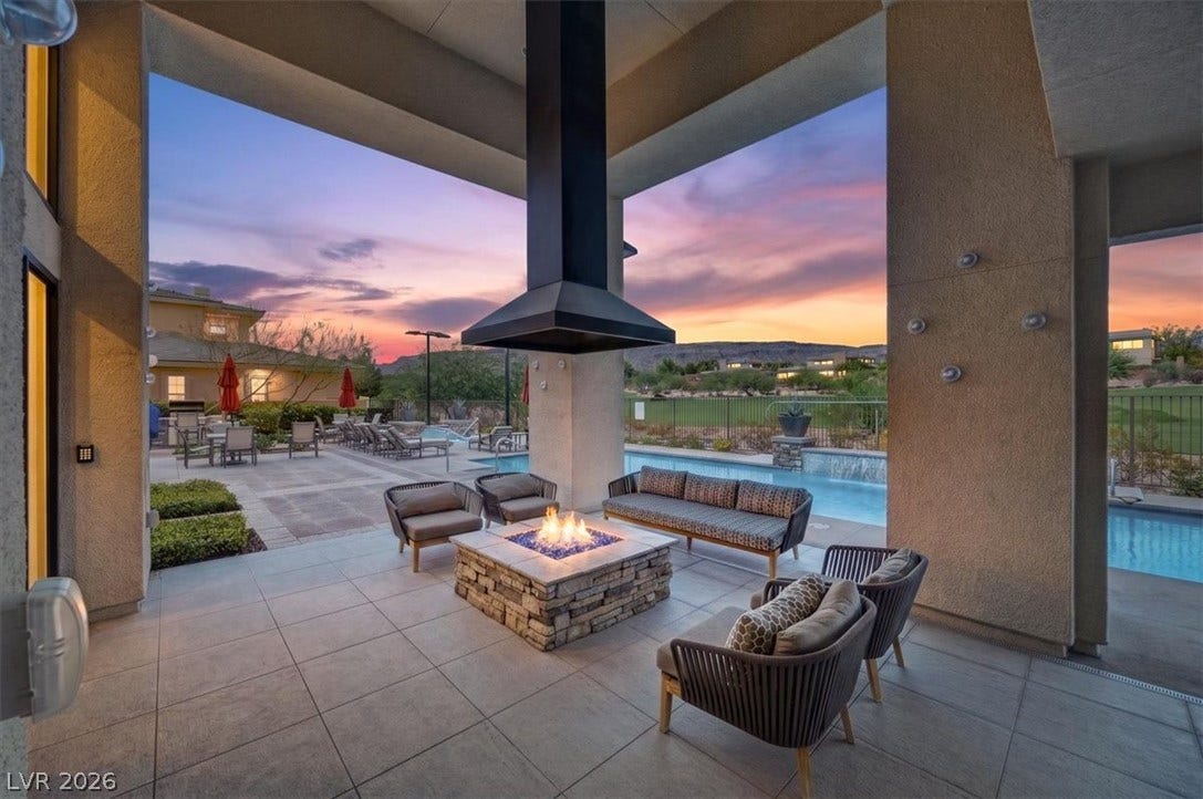 11280 Granite Ridge Drive, #1048, Las Vegas, NV 89135 A stone outdoor fireplace warms the tiled patio overlooking a sparkling swimming pool.
