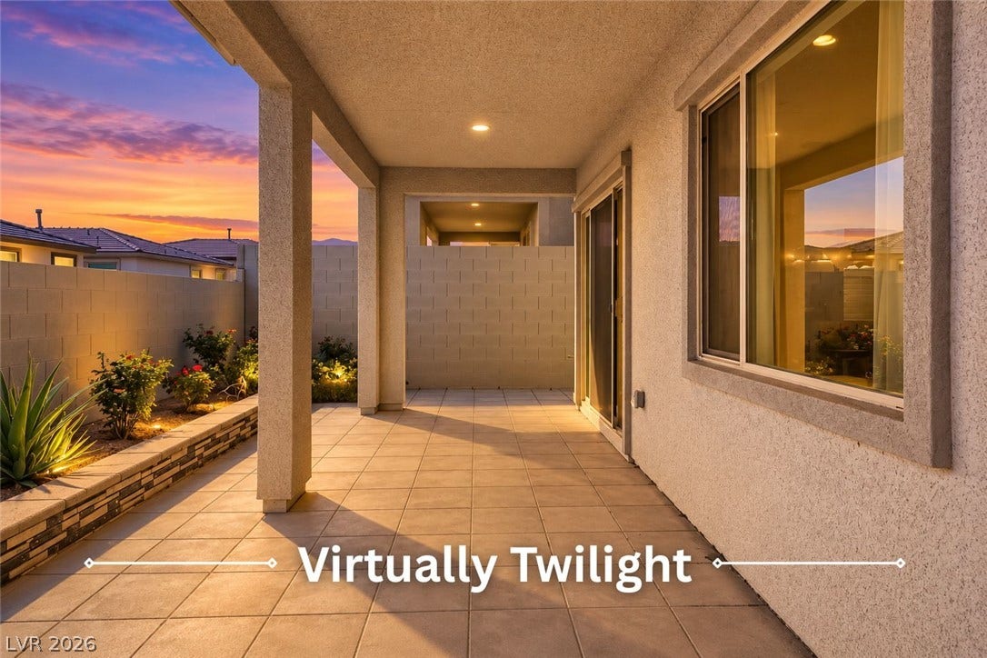 Tiled flooring and stucco pillars define this sheltered outdoor living space beside the yard.