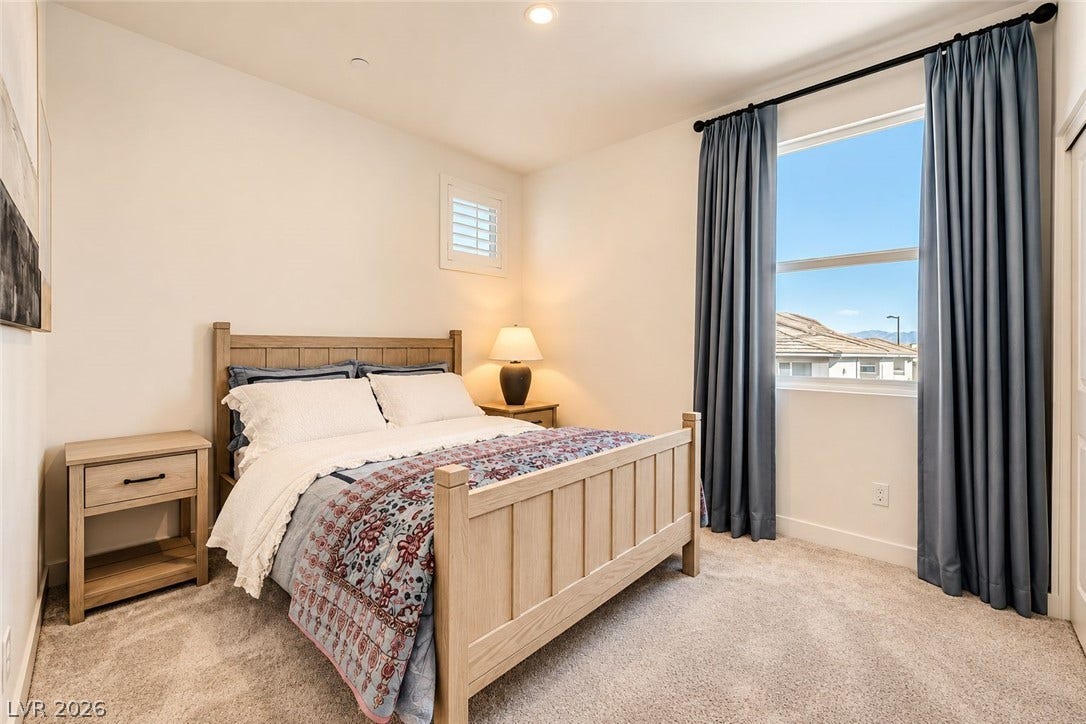 Recessed lighting and soft carpeting create a tranquil atmosphere in this serene sleeping space.