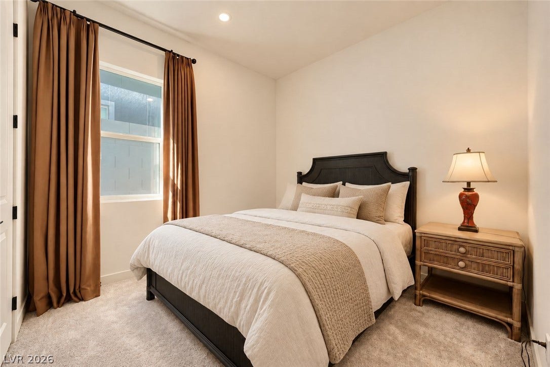 Plush carpeting anchors this inviting bedroom space illuminated by modern recessed lighting.