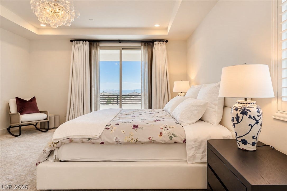 Recessed lighting and a tray ceiling frame a private balcony overlooking distant hills.