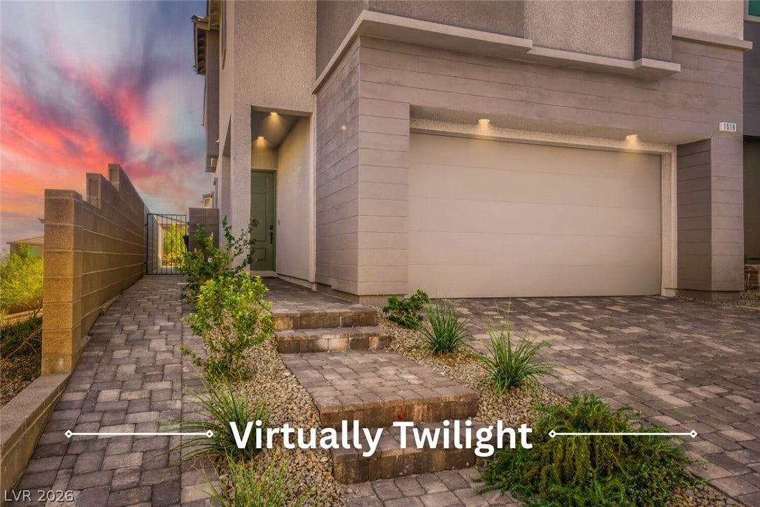 Clean lines and modern stone accents define this stylish contemporary home exterior with paved driveway.