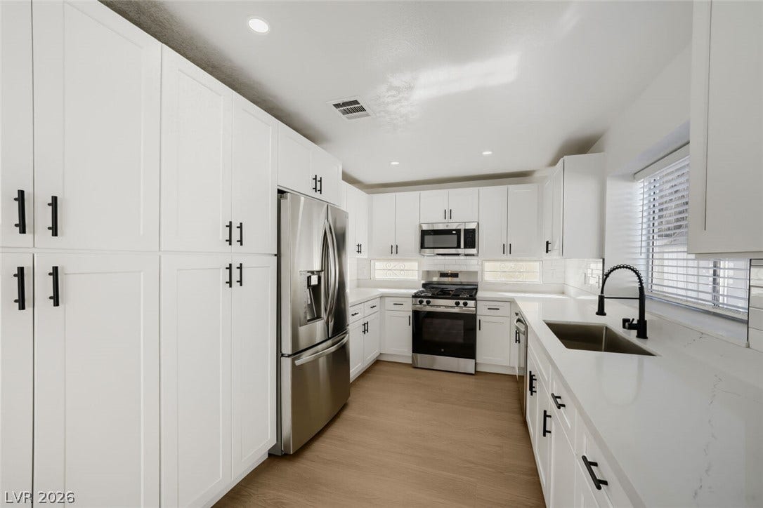 5736 Baffy Circle, Las Vegas, NV 89142 Sleek modern cabinetry and gleaming stone countertops anchor this streamlined culinary space.